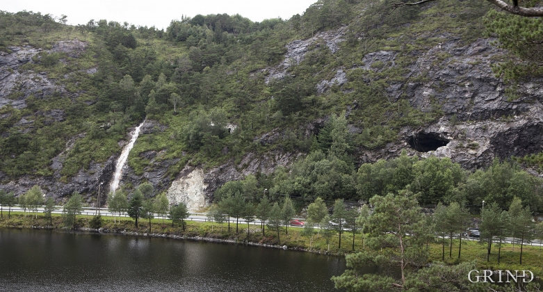Ved Gaupåsvatnet. Det hvite feltet litt til venstre i bildet viser et fersk snitt i anortositten. I åsen i bakenfor ligger anortosittbruddet til Arna steinknuseverk.